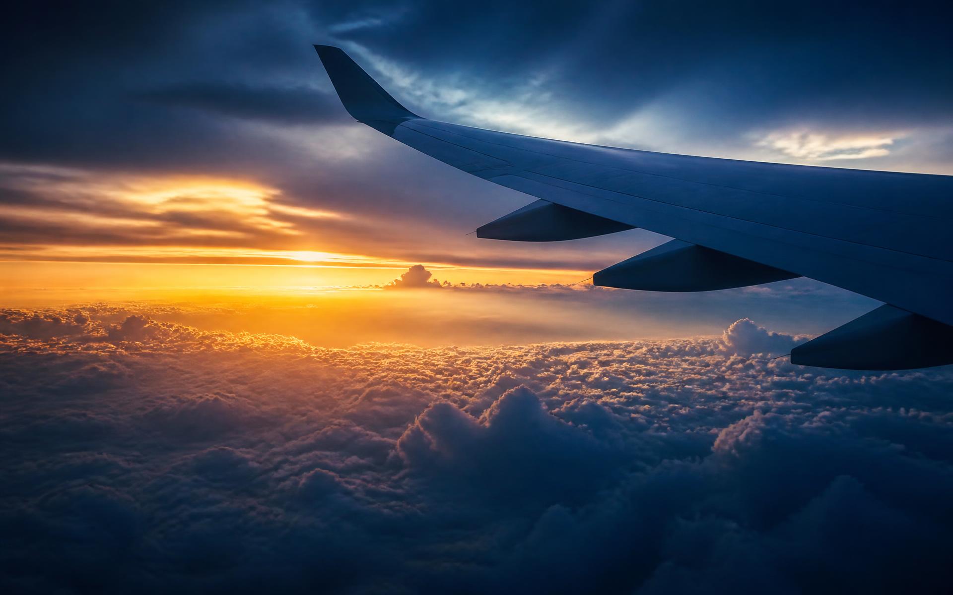 Aircraft wing above a golden sunset cloudscape